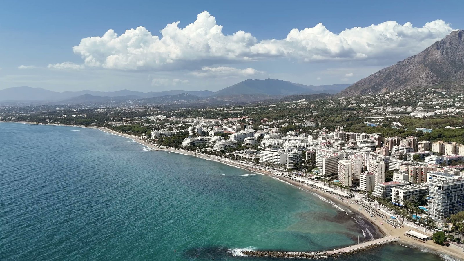 La bahía de Marbella, una villa vista desde un dron, un plano de obra y un recorrido por una villa luminosa: salón, comedor, dormitorio, baño, escalera y terraza
